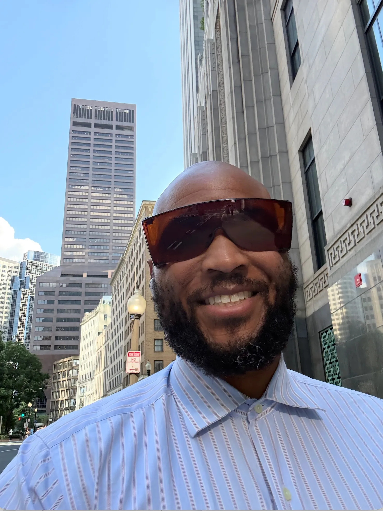 Stanley Griggs standing on a street in downtown Boston, with office towers behind him